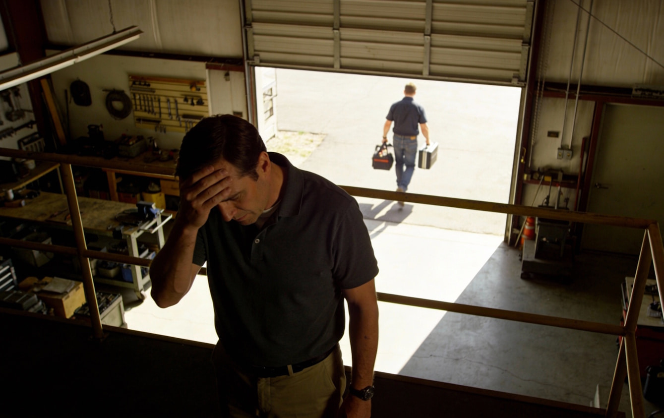 Thumbnail: Small business owner experiencing employee turnover stress as worker leaves with toolbox - HR program prevents costly talent loss